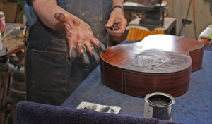 Applying wood filler to a back. It's goopy stuff, but best applied with bare fingertips.